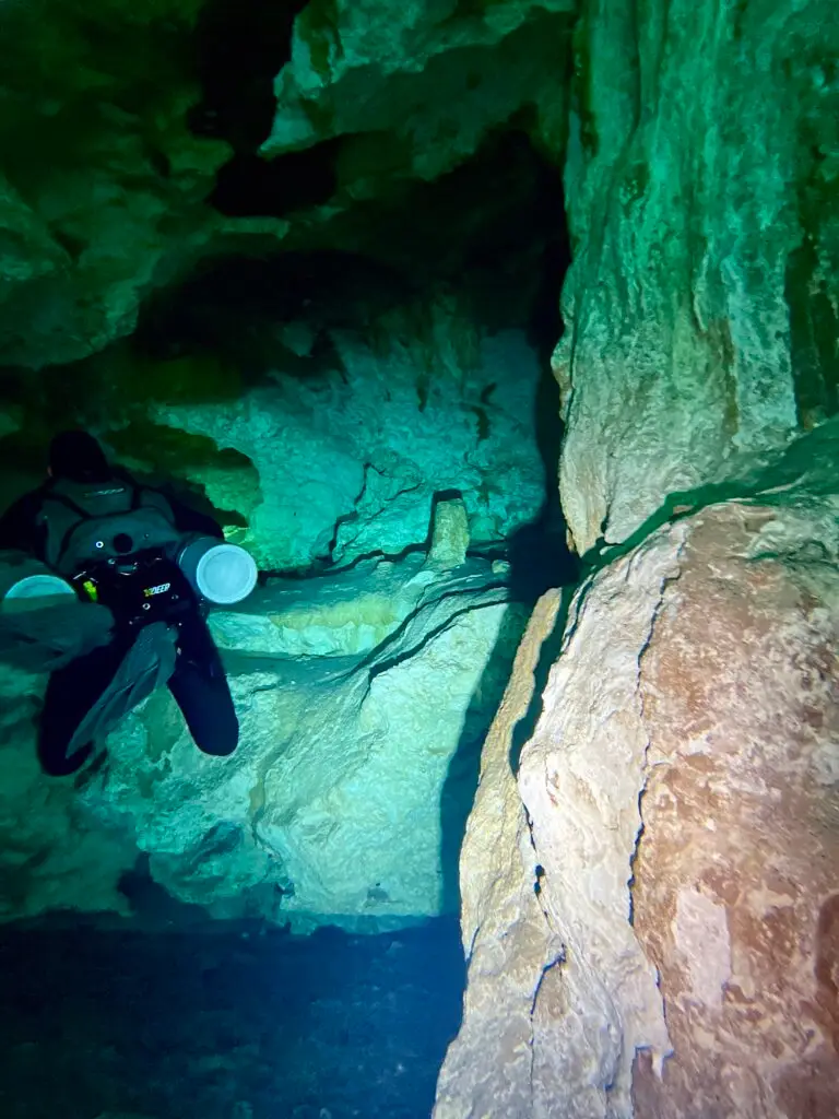 Diver with a dive light among cavern formations