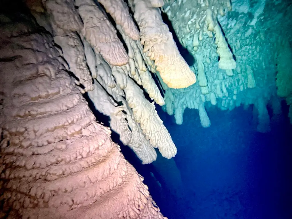 Hells Bells formations hanging over the blue water of Cenote Zapote